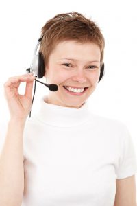 Caucasian woman with a headset on her head, and smiling.