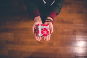 woman's hands with a small wrapped box in her palms.