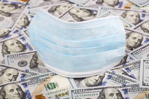 face mask on top of 100 dollar bills.