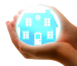 persons hands holding a bubble with a blue house in it.