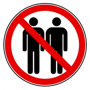 sign with 2 silhouettes standing next to each other with red circle with cross over it. 