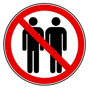 sign with 2 silhouettes standing next to each other with red circle with cross over it. 