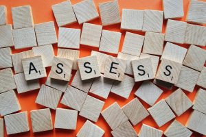 scrabble blocks that spell out the word "assess"