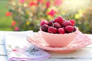 red cherries in a pink bowl. 