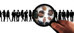 group of people looking down a magnifying glass.