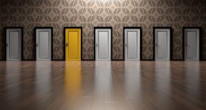 multiple doors next to each other all white, except for one yellow one.