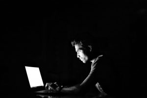 man sitting in front of a computer screen.