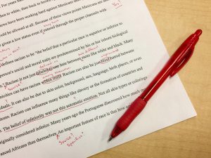 paper with red pen and marks all over writing