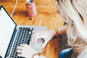 caucasian woman sitting at a table with laptop in front of her