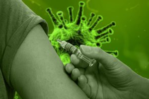 persons arm about to get a vaccine in it with a green background with virus on it