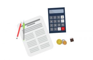 calculator next to a paper with pens on it and coins below it