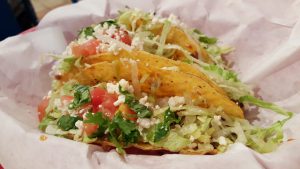 two tacos with lettuce, tomatoes and cheese