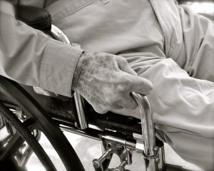 black and white pic of an elderly man sitting in a wheelchair