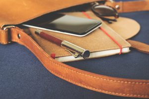 planner and cell phone coming out of a brown bag