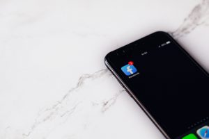 cell phone with facebook app with notification icon on it