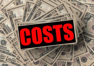 a sign that says "costs" in red over a pile of 10 dollar bills.