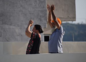 two elderly people doing yoga moves outside.