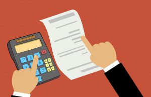 white paper with a calculator and a hand pointing at both. 