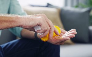 caucasian mans hand holding a prescription pill bottle pouring meds into his hand