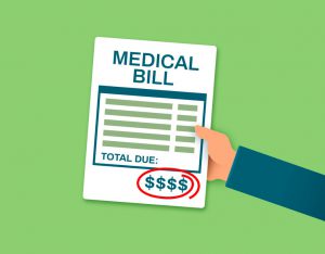 hand holding a paper that says "medical bill" on it with dollar signs on the bottom circled in red.