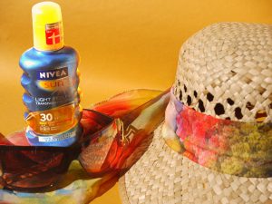 sunscreen spf 30 bottle next to a hat