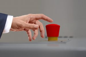 caucasian hand with its pointer finger over a red button