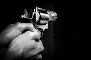 caucasian hands holding a revolver.