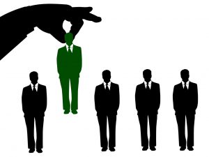 silhouette of a hand picking up a green silhouette og a man in a suit