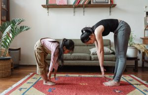 mom and daughter bending down touching their toes