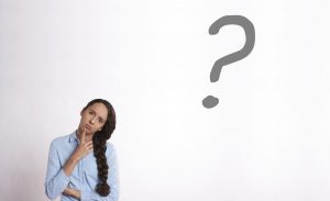 caucasian woman looking confused with a question mark above her head to the right
