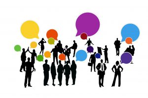 silhouettes of many people with different colored speech bubbles above some