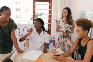 women in an office setting laughing with each other.
