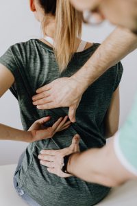 woman pointing to her back with a doctor taking a look at it.