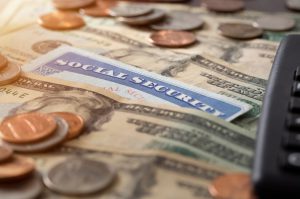 social security card under some money bills and coins