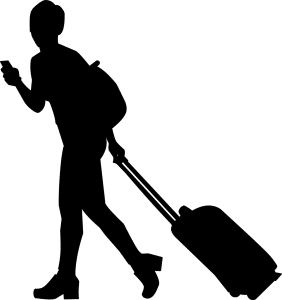 silhouette of a person with a traveling suitcase rolling behind them