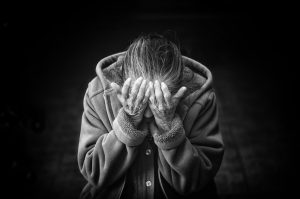 black and white picture of an older caucasian woman with her face in her hands