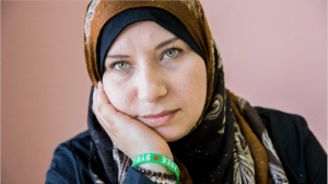 woman with hijab on with her hand on her cheek