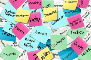 colorful post it notes with motivational words relating to business management on them