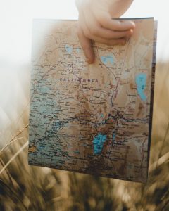 caucasian hand holding a california state map
