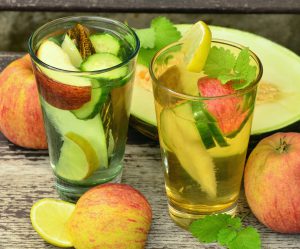 two glasses of water with fruit in it