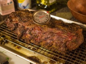 large piece of meat with food thermometer in it