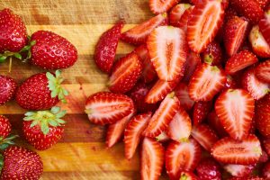strawberries on a chopping block with them split in half