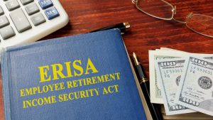 blue book with ERISA on it and money next to it