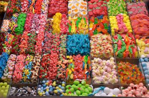 an assortment of different kinds of candies in bins