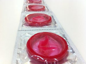 a row of packaged red condoms in a clear package