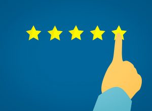 hand with the pointer finger pressing on the 5th star of a review.