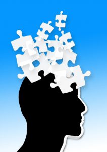silhouette of a head in black with white puzzle pieces coming out of it