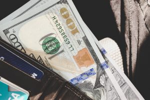 hundred dollar bill sticking out of a wallet.