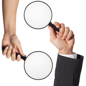 two hands holding a magnifying glass in each hand