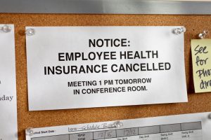 notice on a board that says "employee health insurance cancelled, meeting at 1 pm tomorrow"